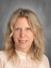 A woman in a white shirt, showcasing her long hair, exuding a calm and composed demeanor.